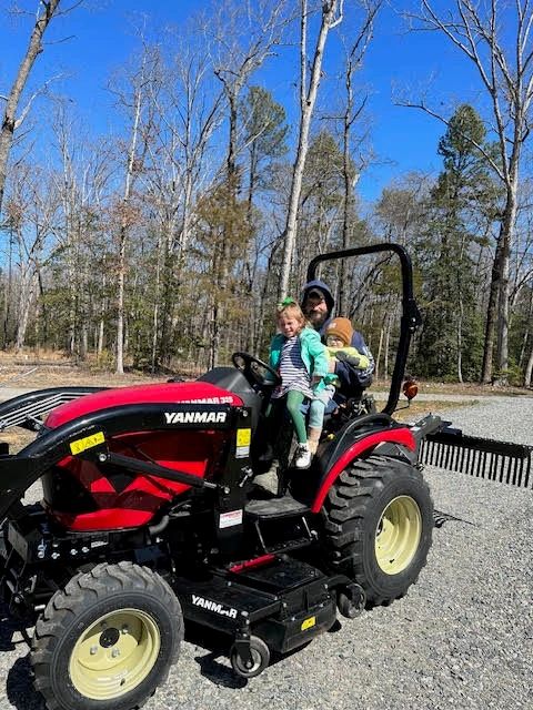 Garrett on the tractor with a child