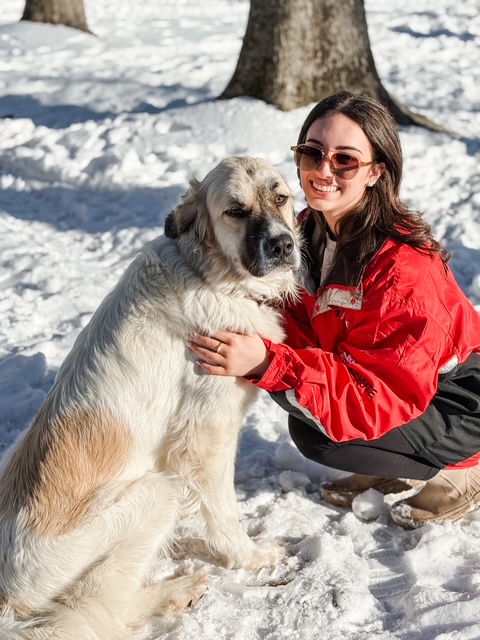 Sophia with a farm dog in the snow